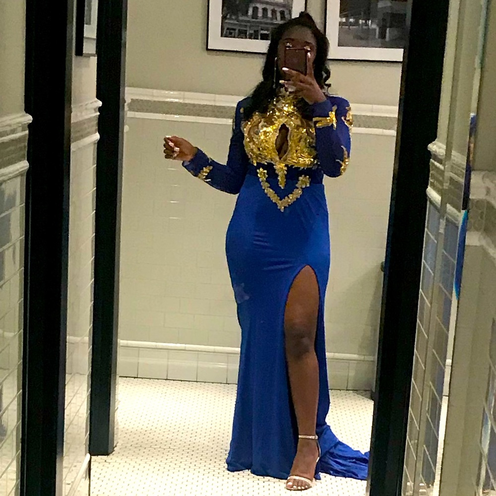 This is a royal blue gown with elaborate gold sequin detailing and a long train.
